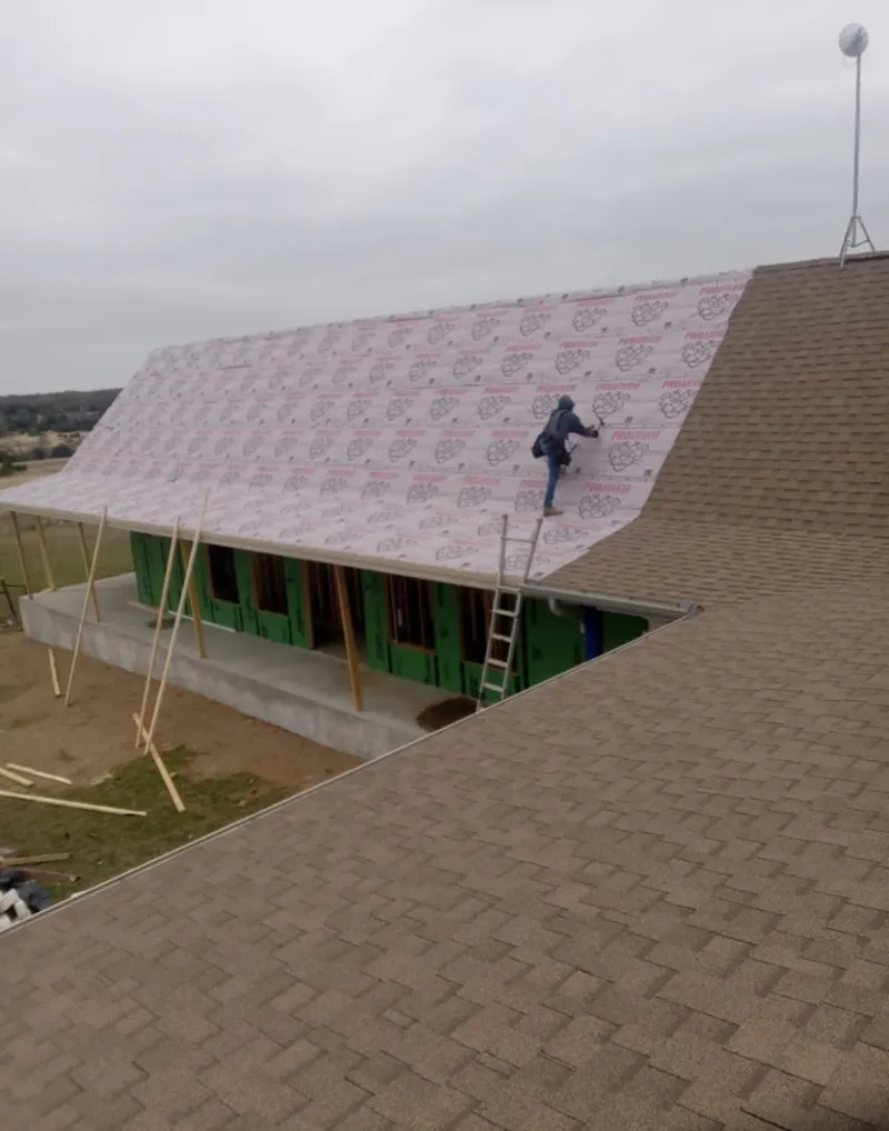 Worker preparing underlayment for a metal roof installation in Sudden Valley